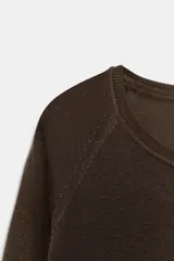 Jersey de punto fino con diseño de rayas horizontales en azul marino y blanco, cuello redondo y manga larga con corte raglán.