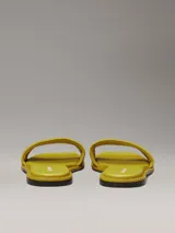 Ojotas amarillas de lona con logo de Calvin Klein grabado en la tira.