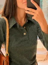 Sweater de punto fino en color verde oscuro, con cuello polo y cierre frontal de tres botones. Presenta mangas largas y un ajuste al cuerpo.