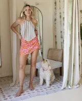 Falda corta tipo pareo con estampado floral en tonos rosados y naranjas, con ajuste lateral mediante lazo.