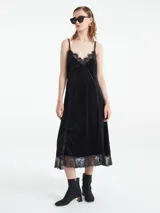 Vestido midi negro de terciopelo con breteles finos y encaje en escote y ruedo.