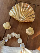 Pinza para el pelo con diseño de concha marina, acabado metálico plateado brillante.