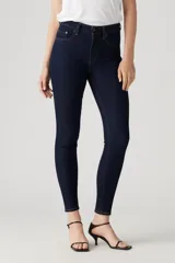 Jeans de tiro alto color azul oscuro, corte ajustado en cadera y muslos, con pierna skinny y cierre de cremallera.