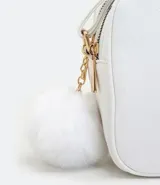 Bolso pequeño femenino de PU color blanco, con correa para cruzar, cierre de cremallera, divisorias internas y pompón decorativo.