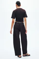 Pantalón cargo de corte holgado en color marrón, confeccionado en mezcla de algodón y nailon. Presenta cintura elástica de talle alto y perneras estilo globo con bolsillos tipo parche a los lados y costuras visibles en la parte delantera.