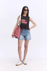 Tote bag amplia con estampado de ondas en tonos azules y verdes, asas largas de color beige, cierre superior con borde rosado y logo bordado en el centro.