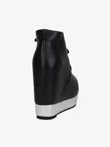 Zapato tipo botín de cuero negro, con cordones y plataforma integrada de color plateado.
