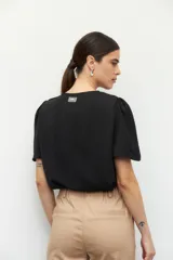 Top color verde claro, de mangas cortas abullonadas y cuello redondo.