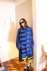 Bufanda de punto de gran tamaño, con diseño de rayas horizontales en azul y negro, y detalles en amarillo en los extremos.