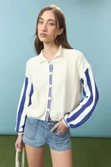 Cardigan de algodón color azul con mangas largas de rayas verticales anchas en tonos azul y celeste, puños en rojo, y bordado en la espalda con diseño de escudo nacional.