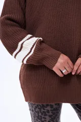 Sweater de punto color marrón con cuello redondo, puños y cuello con detalles de rayas blancas en contraste. De corte holgado y manga larga.