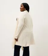 Cardigan de punto color marrón, con diseño alargado y puntas asimétricas. Presenta mangas largas, cuello tipo chal y detalles de textura canelada en los laterales.
