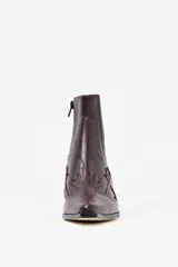 Bota corta estilo texano de cuero color chocolate con textura de cocodrilo y detalles de costuras decorativas. Cuenta con taco cuadrado y punta fina.
