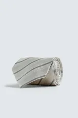 Corbata ancha confeccionada en tejido de seda con diseño de rayas diagonales en tonos beige y gris.