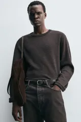 Jersey de corte relajado con cuello redondo y manga larga, confeccionado en tejido jacquard con diseño de rayas horizontales finas.