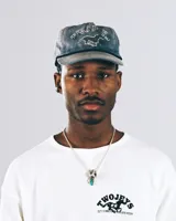 Gorra tipo trucker color amarillo con bordado frontal que incluye la frase 'TWOJEYS' y la silueta de un caballo. Presenta un cordón decorativo negro en la base de la visera y el texto 'CITY COWBOYS' bordado en el lateral.