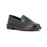 Mocasines Ramarim de cuero negro con textura grabada en la parte superior y detalle de aplique metálico dorado. Presenta suela plana de goma con borde en tono marrón.