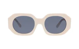 Lentes de sol con armazón de acetato en color crema y cristales oscuros. Presentan un diseño de forma geométrica redondeada.