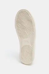 Zapatilla urbana color off-white con detalle trasero en contraste de tono tostado y suela engomada. Presenta pespuntes decorativos en el cuerpo y cierre de cordones.