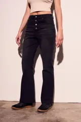 Pantalón de jean negro de corte flare con tiro medio y cierre frontal con botones.