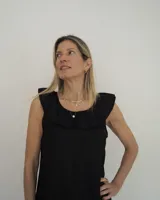 Vestido midi de lino color beige, de corte suelto, sin mangas y con escote redondo decorado con un volado amplio.