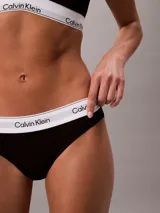 Bombacha clásica tipo bikini de Calvin Klein, color negro, confeccionada en mezcla de algodón, modal y elastano. Presenta una pretina elástica distintiva con el logo de la marca en contraste y ofrece cobertura total en la espalda.