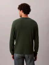 Remera de manga larga Calvin Klein en color verde oscuro, confeccionada en tejido térmico de punto con textura de nido de abeja. Cuenta con cuello redondo, puños acanalados y un pequeño parche con el logo de la marca en el pecho.