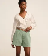 Short regular de talle alto confeccionado en sarga de color marrón, con trabillas para cinturón, cierre con botón y cremallera, bolsillos delanteros y traseros, y pespuntes en contraste.