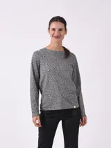 Remera de manga larga con estampado animal print pequeño en tonos grises y negros. Presenta un detalle de botones decorativos amarillos en el hombro derecho y un corte recto clásico.