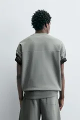 Sudadera de manga corta color marrón oscuro, con cuello redondo y bajo acabado en rib. Presenta un corte relajado y holgado (boxy fit).