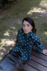 Camisa verde con lunares violetas, cuello clásico, mangas abullonadas y lazos laterales para ajustar.