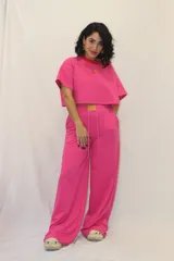 Pantalón de jogging de corte ancho y tiro alto, con cintura elástica, cordones ajustables y un aplique decorativo de acrílico en el frente. Cuenta con bolsillos laterales.