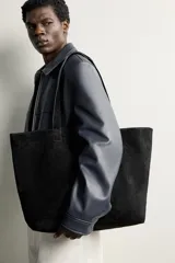 Bolso tipo shopper de piel con acabado serraje, de diseño amplio con compartimento principal y dos asas de hombro.