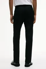 Pantalón de traje de corte ajustado, con cierre y corchete oculto, bolsillos laterales y bolsillos traseros ribeteados. Presenta raya marcada en las piernas y diseño con margen de costura en la pretina.