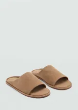 Sandalias planas de piel bovina en color tostado, con diseño destalonado, puntera abierta y una sola tira ancha en el empeine.