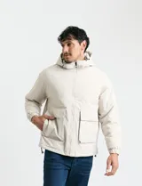 Campera impermeable con capucha, cierre frontal completo y bolsillos frontales con tapa. Presenta elásticos en los puños y cordón regulable en el ruedo, con interior térmico.