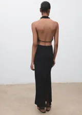 Vestido largo negro de corte entallado con cuello drapeado y espalda descubierta. Presenta un diseño sin mangas y una abertura trasera en el bajo.