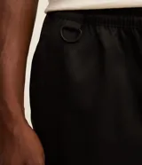 Pantalón cargo recto color beige, con cintura elástica ajustable con cordón, bolsillos laterales tipo cargo con solapa y bolsillos con cremallera.