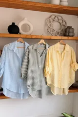 Camisa de algodón con diseño de rayas verticales en tonos amarillo y blanco, de corte clásico y manga larga.