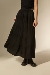 Falda larga de corte amplio con diseño de frunces horizontales y caída fluida.