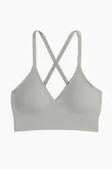 Top deportivo de tejido funcional DryMove™ gris, de sujeción media, con tirantes ajustables cruzados en la espalda y copas con relleno extraíble.