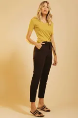 Pantalón de corte recto y tiro alto, color naranja, con bolsillos laterales y cierre frontal con botón y cremallera. Incluye un cinturón fino de cuero marrón.