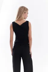 Top negro de corte al cuerpo, sin mangas, con escote redondo y diseño liso.