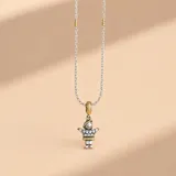 Collar de cadena tourbillón en plata 925 con detalles en oro, que sostiene un dije en forma de niño con acabado bicolor en plata y oro, decorado con circonias brillantes en el torso.
