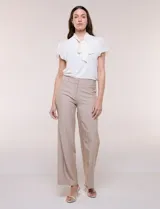 Pantalón sastrero de talle alto y corte wide leg, color beige, con pretina ancha, pasacintos, bolsillos laterales funcionales y bolsillos traseros ojalados.