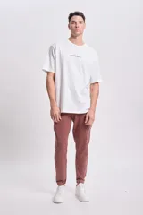 Pantalón deportivo cargo jogger color marrón con bolsillos laterales y tobillos ajustados.