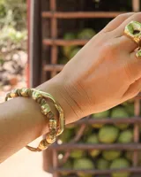 Pulsera artesanal compuesta por una serie de cuentas metálicas irregulares ensartadas en un hilo de algodón natural. Diseño rústico y minimalista.