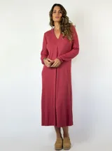Vestido midi de punto acanalado en color bordó, con escote en V y manga larga. Presenta un corte recto y fluido con un detalle de pliegue central en el frente.