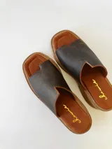Sandalias de cuero color chocolate, con tira ancha sobre los dedos y suela de goma con plataforma.