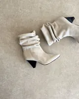 Botines dorados de cuero vacuno con punta fina y tacón aguja.